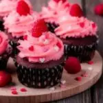 1Chocolate cupcakes with pink cream, sugar hearts and fresh raspberries for St. Valentine's Day