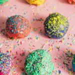 1Couple of colorful sprinkled donuts on a pink pastel background. Delicious homemade bakings.